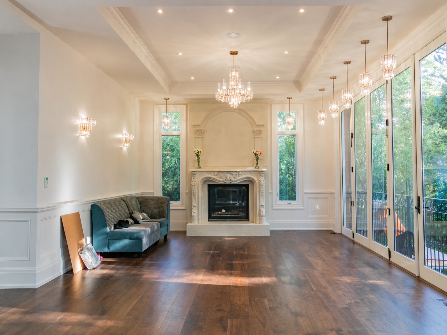 Elegant living room with stone fireplace, chandeliers, and Level 5 drywall finish, Toronto