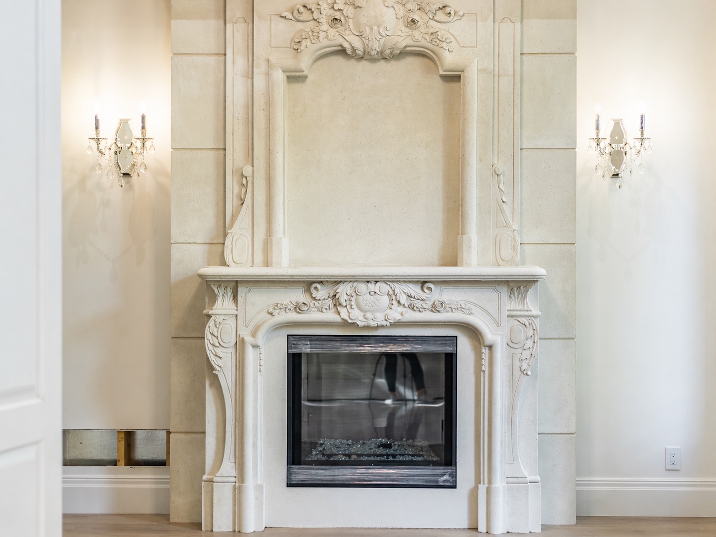 Elegant stone fireplace with crystal sconces and smooth drywall walls in Etobicoke