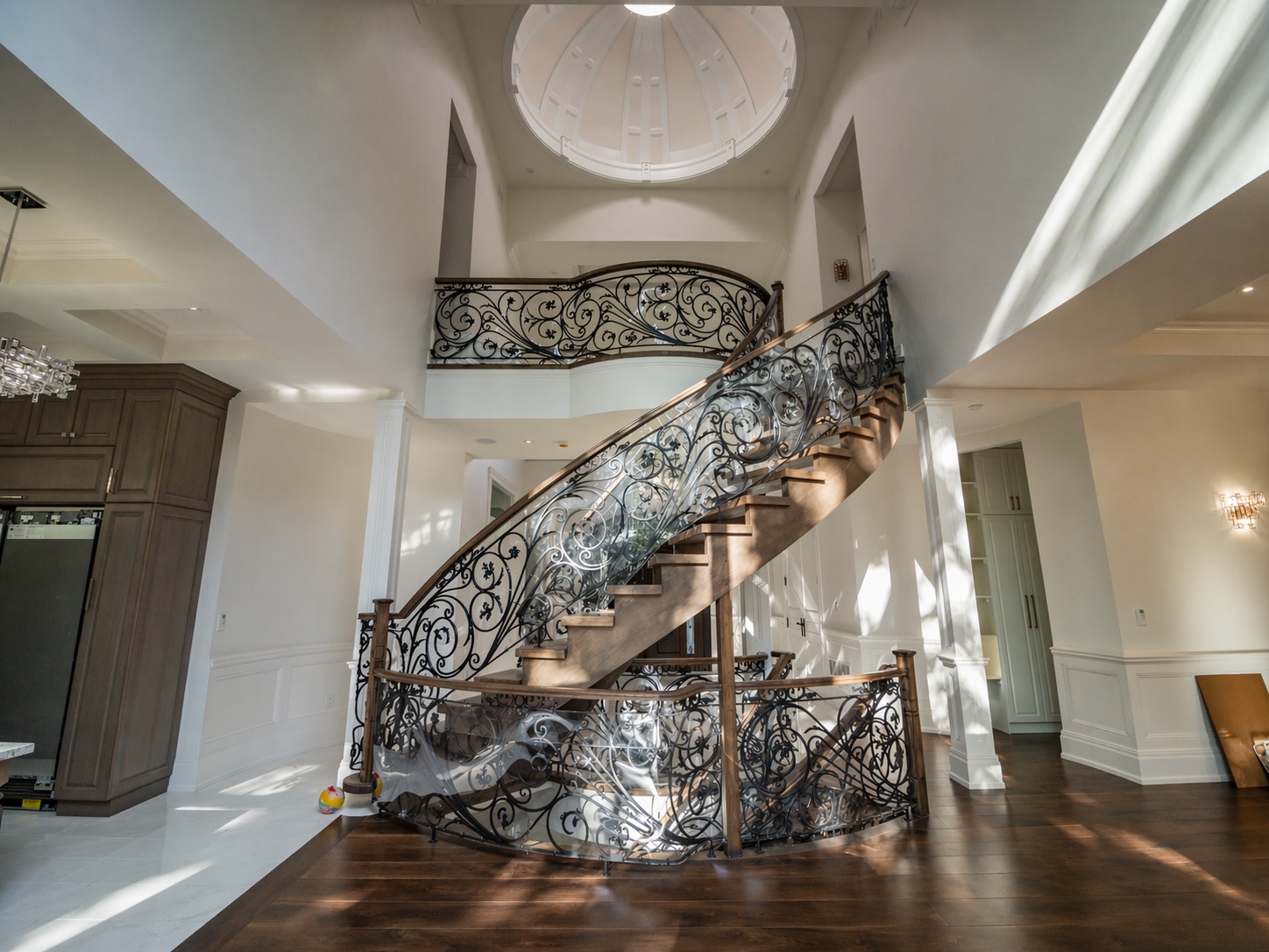 Grand foyer with sweeping iron staircase and dome ceiling — full-home renovation, Toronto