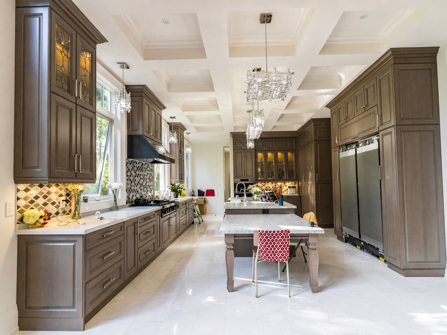 Luxurious modern kitchen with marble island, coffered ceiling, and smooth drywall finish