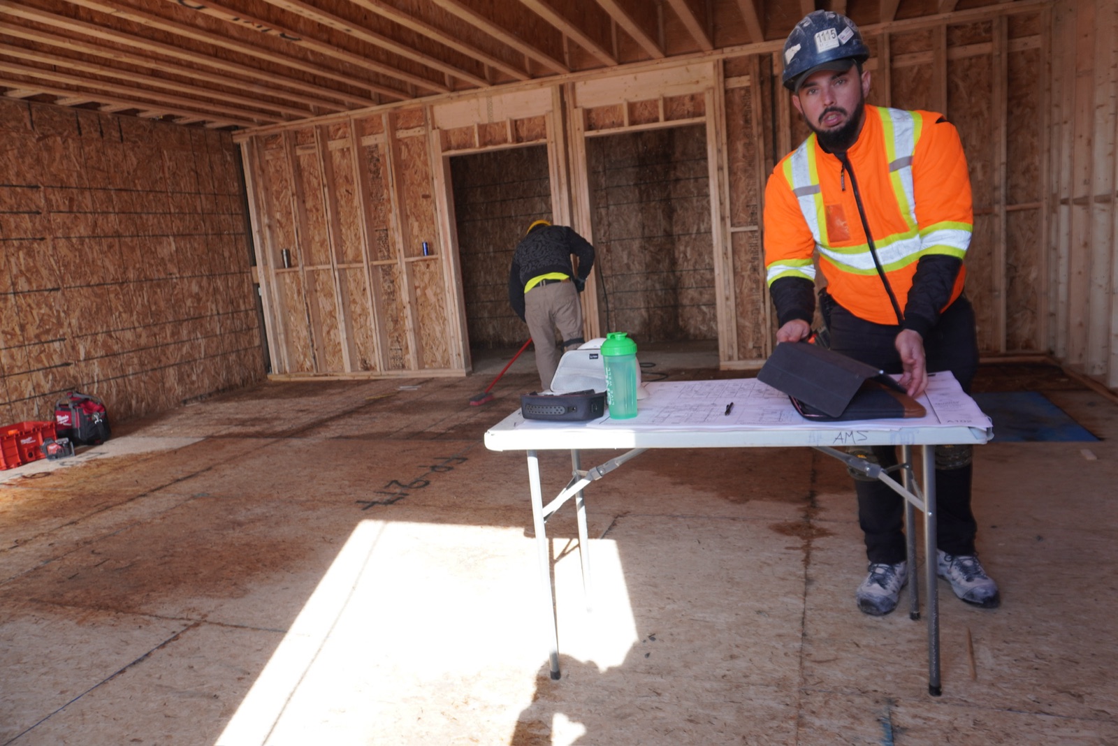 Crew reviewing drawings on a framed hotel floor before layout