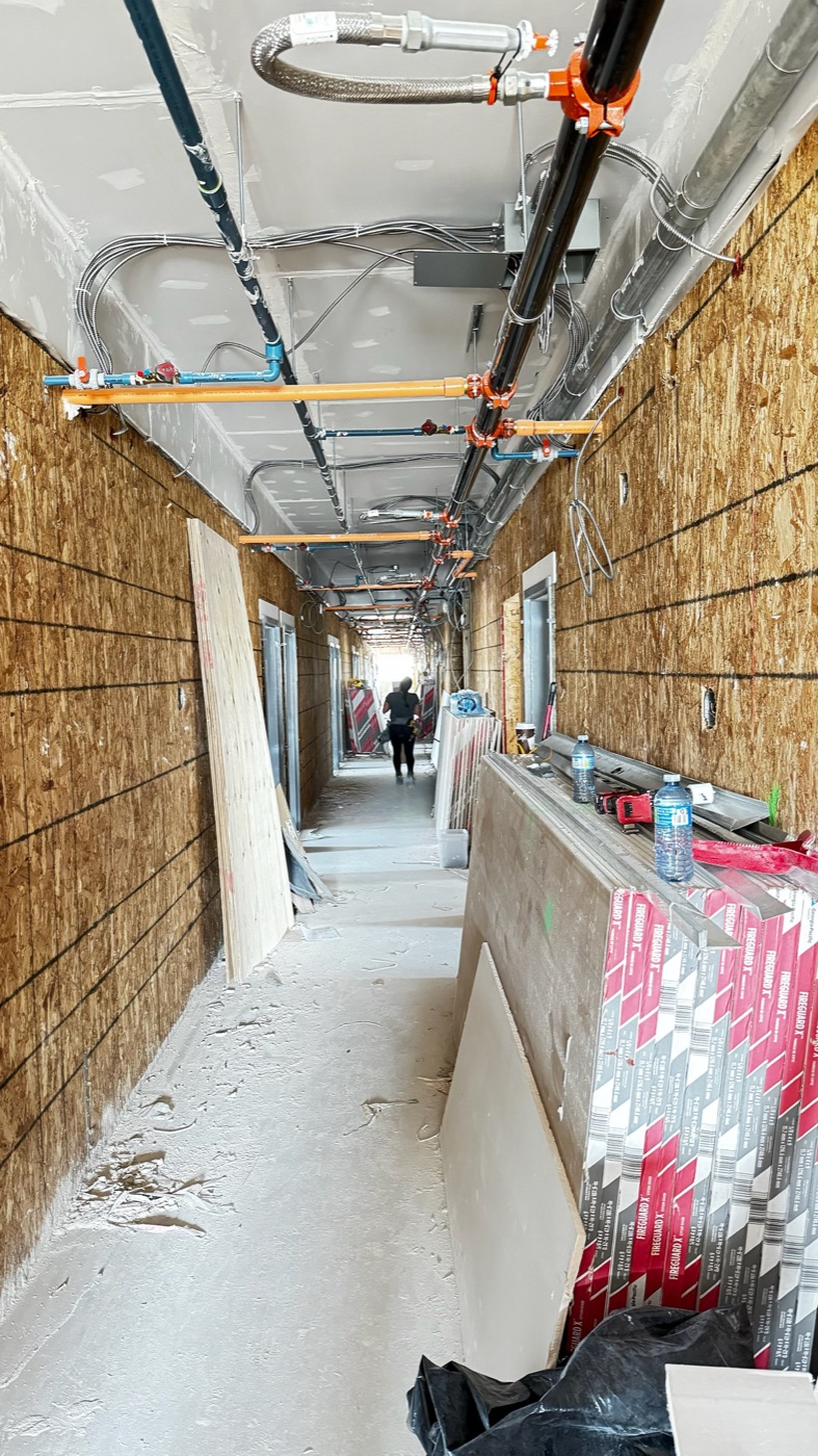 Hotel corridor with rough-ins complete before board