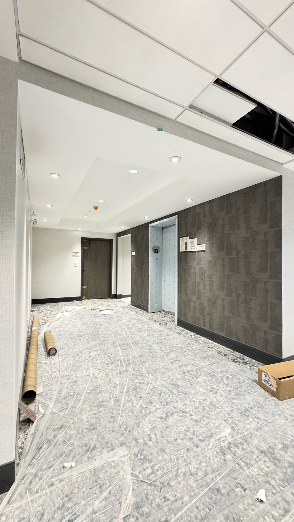 Finished drywall bulkhead and T-bar ceiling in a hotel lobby corridor, built by True Drywall Contracting