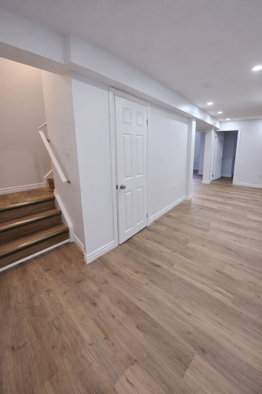 Finished residential basement hallway with smooth drywall walls and ceilings