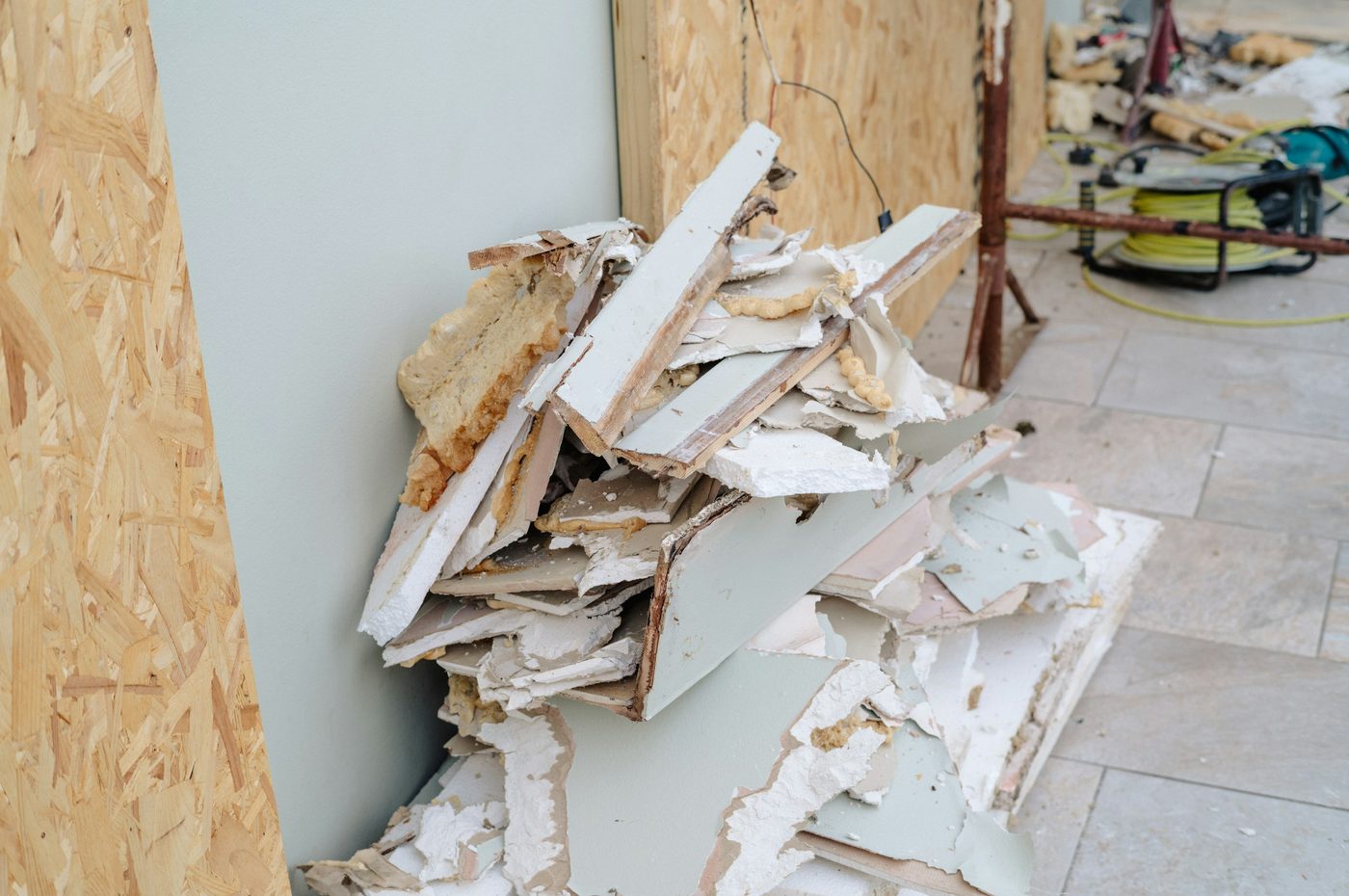 Broken gypsum board torn out of a wall and piled for removal